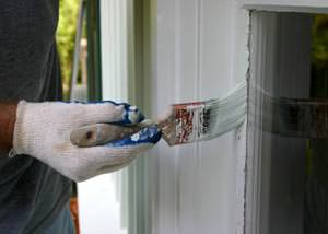 Putting on a second coating of paint on a Shafter home